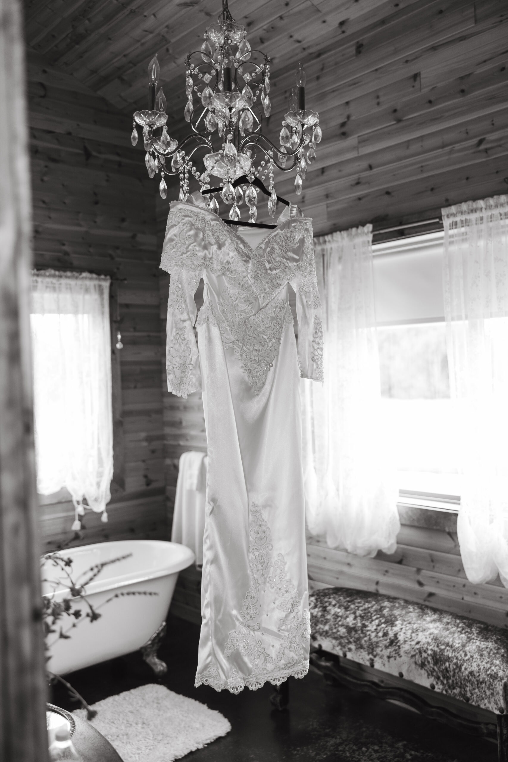 Western lace wedding dress hanging on a crystal chandelier inside The Hideout at Doves Rest Cabins, Palo Duro Canyon.