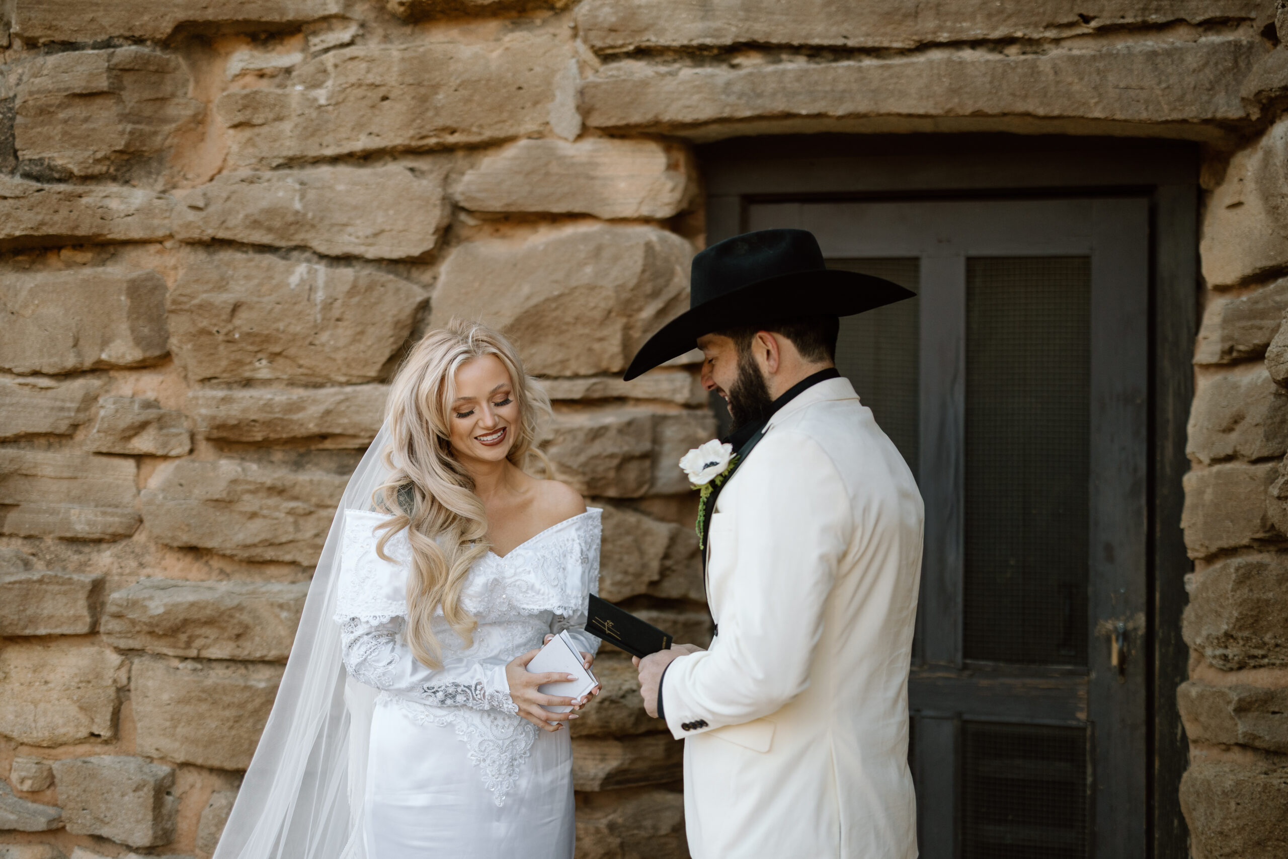 Bride in a fringe cathedral veil and groom in a white tuxedo jacket at Palo Duro Canyon State Park.
