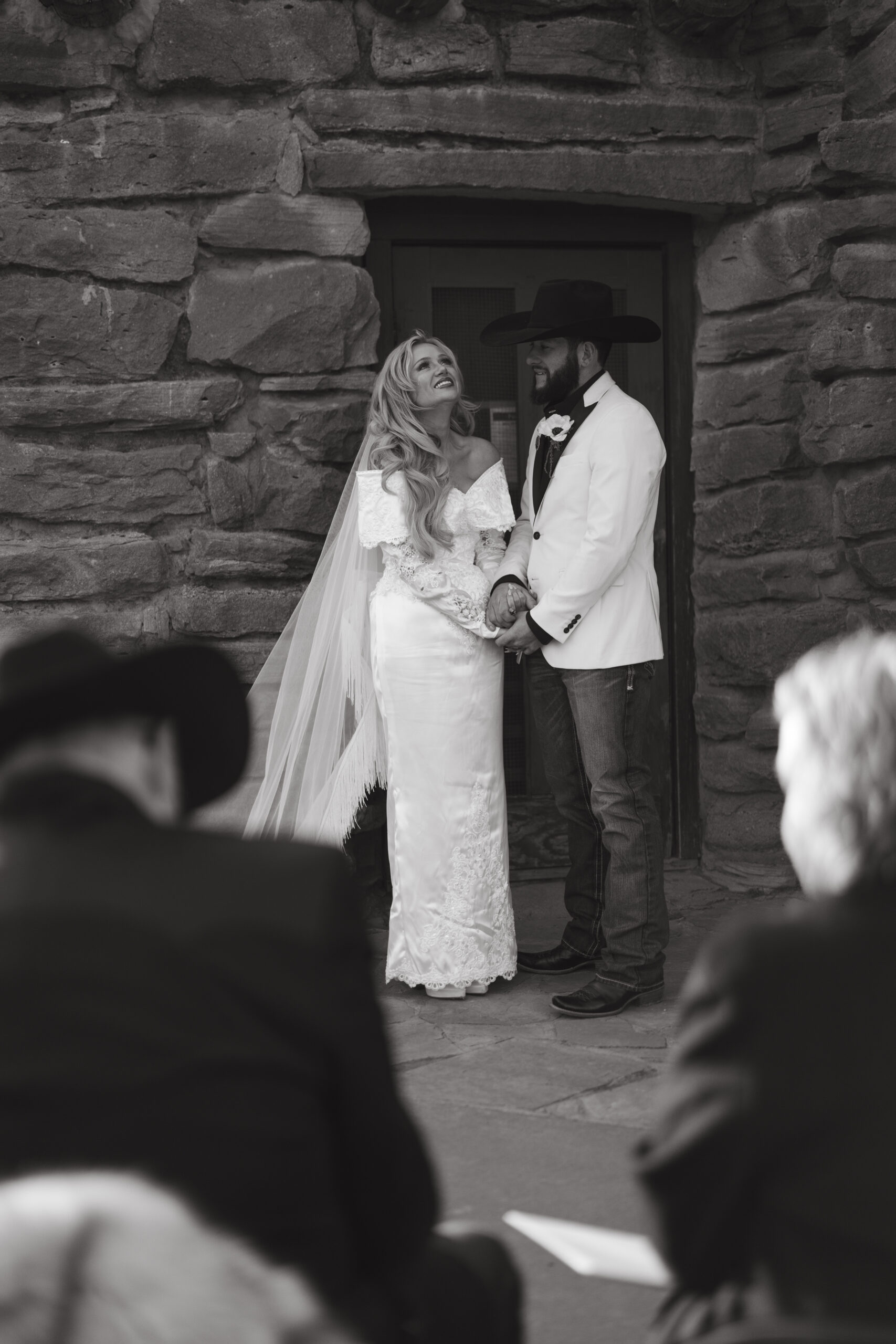 Bride in a fringe cathedral veil and groom in a white tuxedo jacket at Palo Duro Canyon State Park.