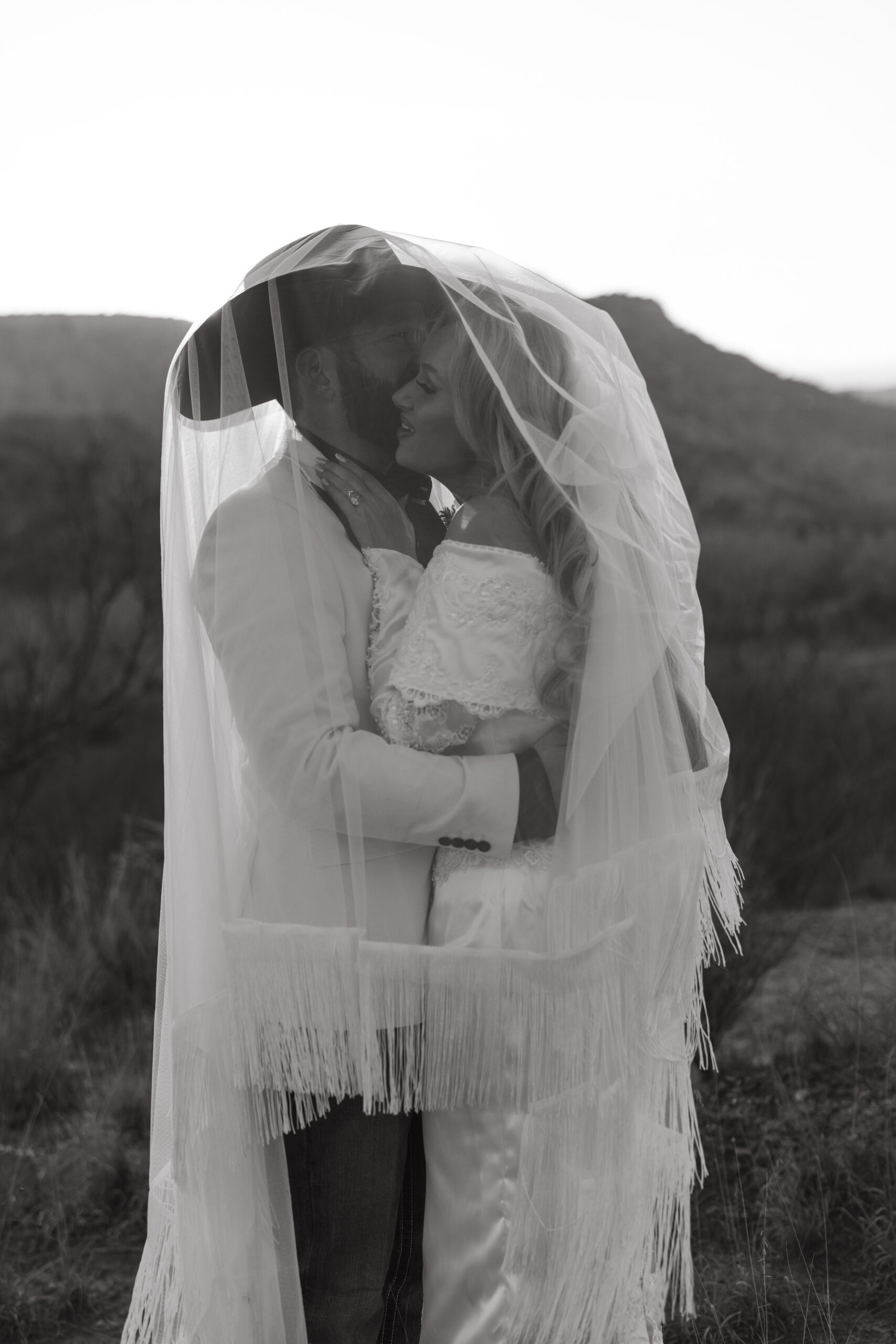 Romantic sunset elopement photo of a couple under the veil in the desert landscape of Palo Duro Canyon, Texas.