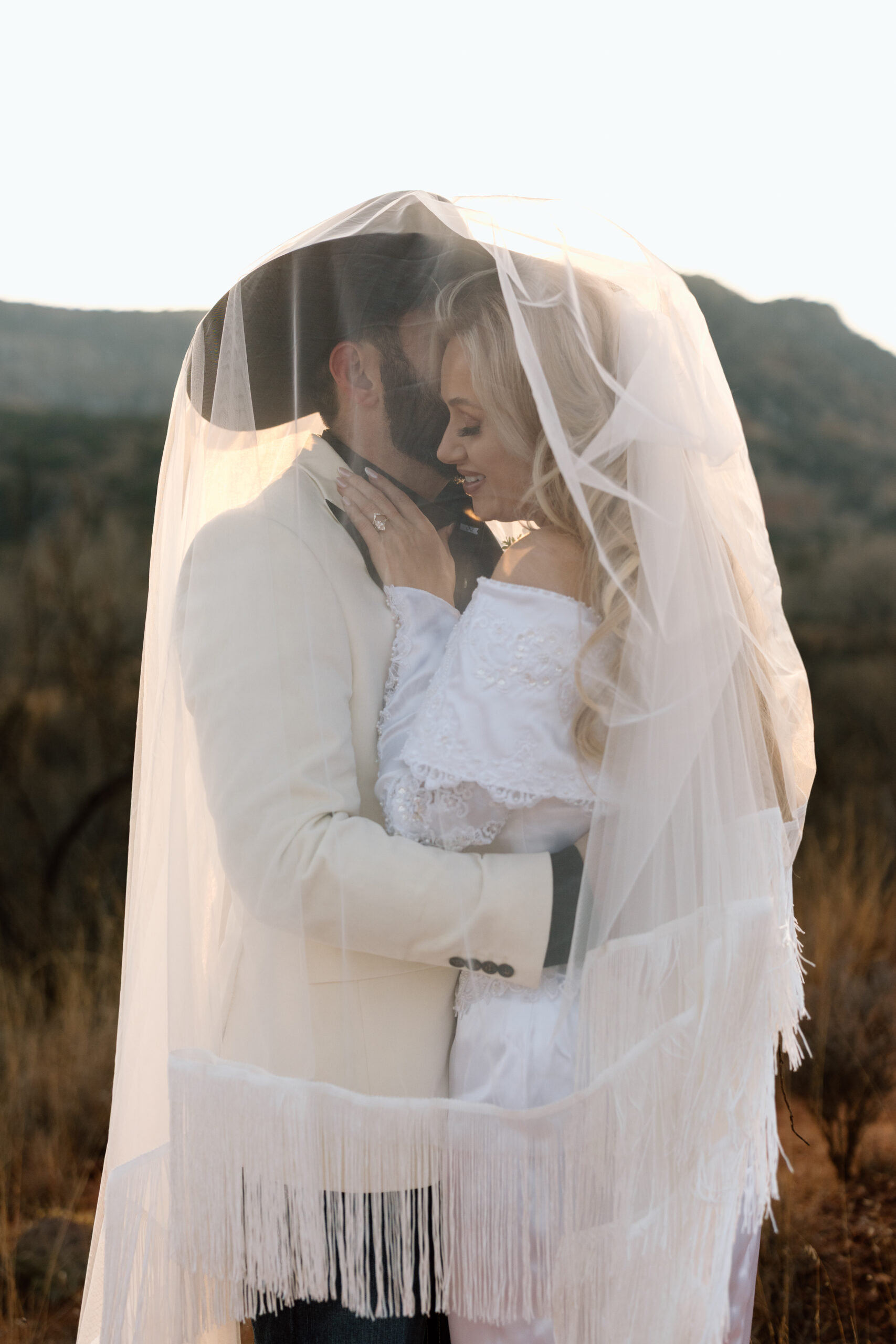 Romantic sunset elopement photo of a couple under the veil in the desert landscape of Palo Duro Canyon, Texas.