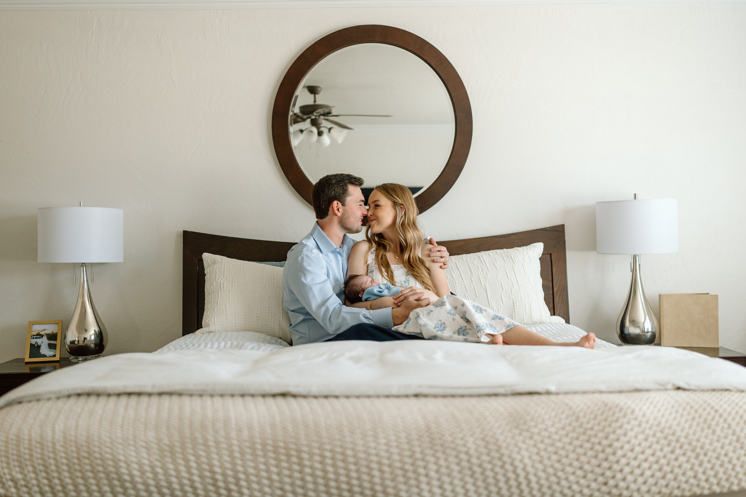 Lifestyle newborn photography tips for using natural window light in a master bedroom.