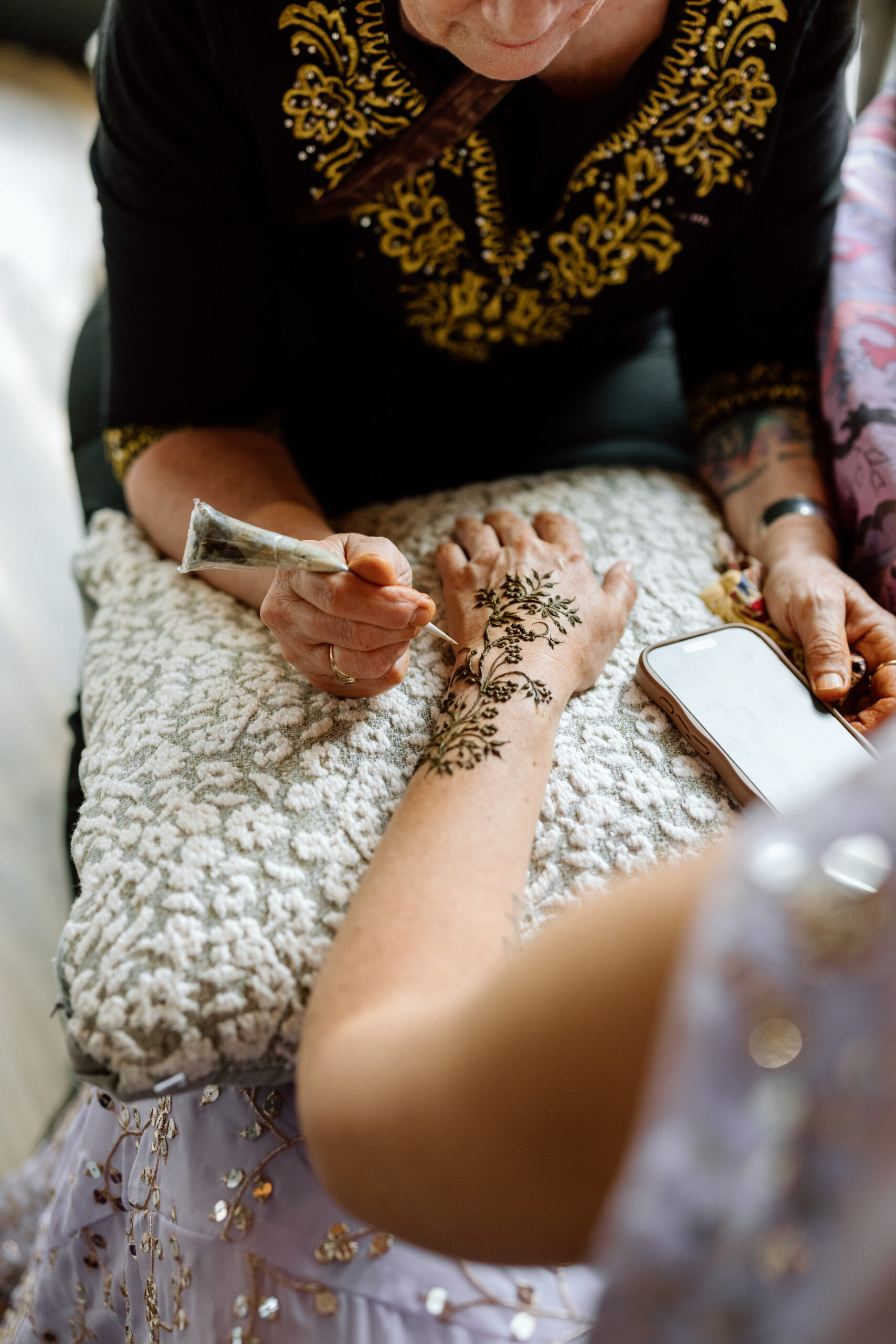 Detailed Mehndi artistry being applied during a two-day Colorado wedding celebration.